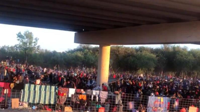 难民被圈在临时营地里，桥洞下的空地上铺着衣服、床单以供休息